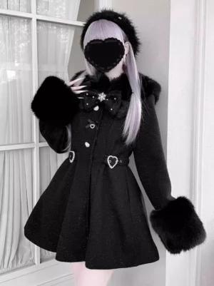 Model wearing black sweet lolita wool overcoat with fuzzy collar and cuffs, light purple hair, heart face mask, showing waist-cinched A-line silhouette and romantic heart buckle details in indoor window setting