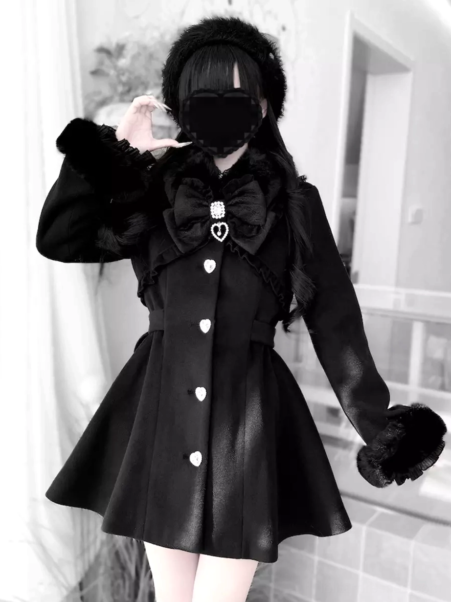 Black Lolita wool overcoat full front model view with furry pom-pom cuffs, matching collar bow, and white curtain background