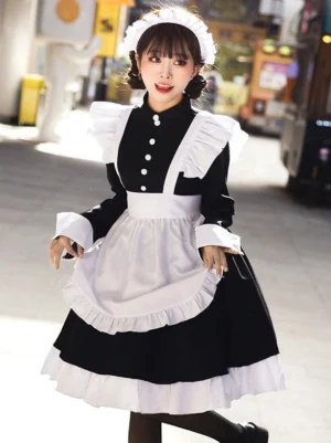 Black maid lolita dress front full-body view featuring ruffled white apron, stand collar with white buttons, and included maid headwear on female model outdoors