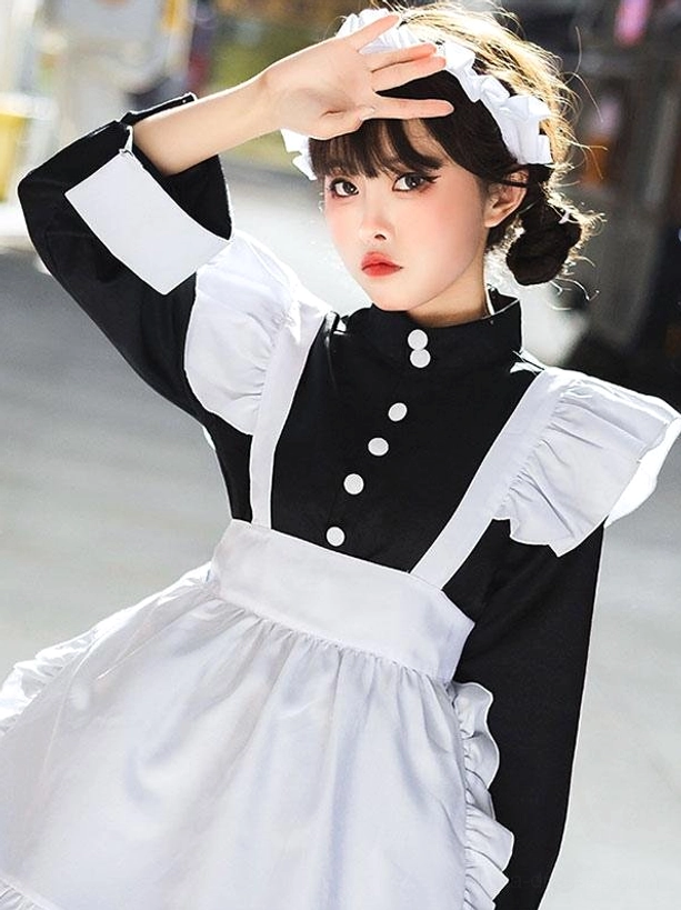 Close-up front view of black maid lolita dress highlighting stand collar with dual white buttons, ruffled shoulder pieces, and white apron detail