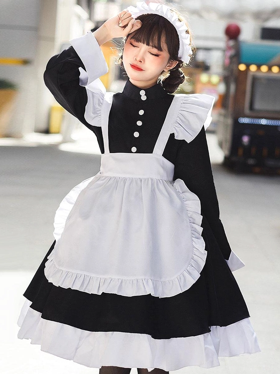 Three-quarter angle shot of black maid lolita dress showcasing ruffled apron edge, front button placket, and frilled maid headband accessory