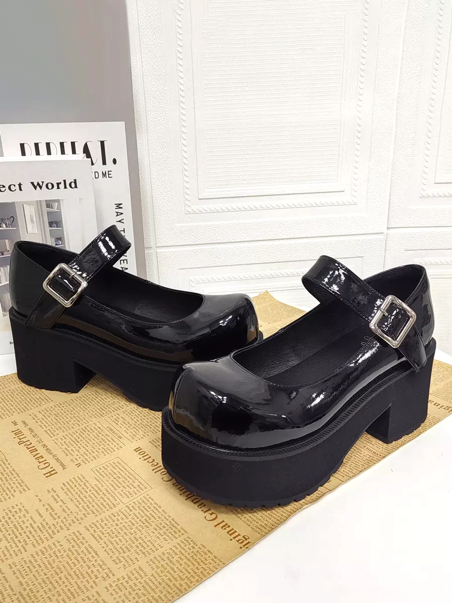 Pair of black patent leather Mary Jane platform lolita heels with marked 8cm heel height and silver buckle straps displayed in three-quarter front view on decorative background
