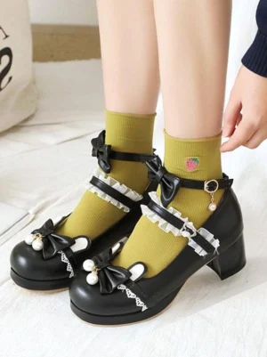 Black PU leather Mary Jane lolita shoes with double pearl bowknots and lace ankle strap, top-down on-foot view featuring yellow strawberry-printed socks and decorative block heel