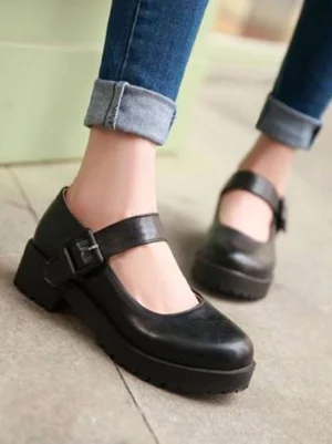 Black Mary Jane platform Lolita shoes with round toe and buckle ankle strap, worn on-foot with rolled blue jeans showing chunky lug heel and smooth PU leather construction