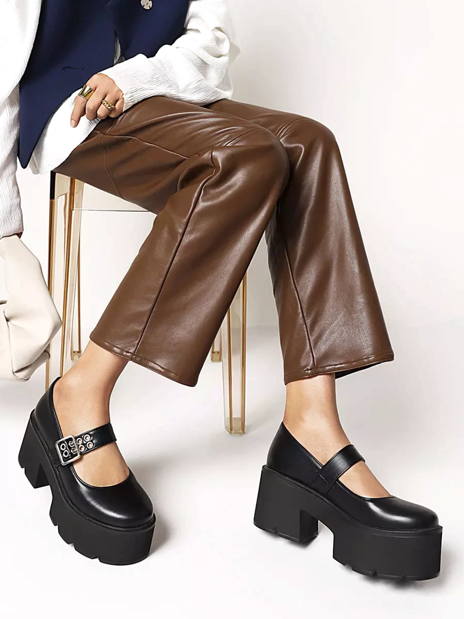 Black platform Mary Jane lolita shoes low angle full foot view model wearing brown leather pants and blazer with chunky platform sole