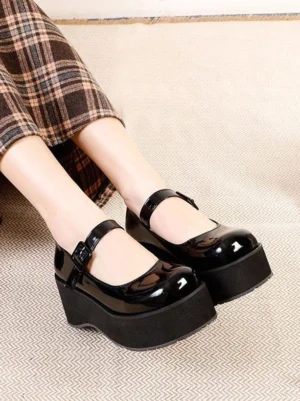 Black glossy patent leather Mary Jane platform pumps side profile showing chunky platform heel and ankle strap with polished buckle closure lolita shoes