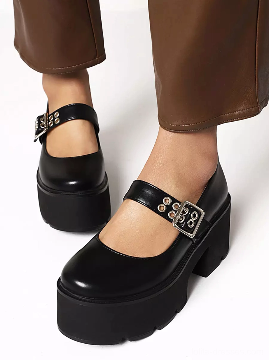 Black matte platform Mary Jane lolita shoes low angle side view on model wearing brown leather pants with metal buckle ankle strap