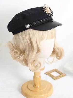 Black military-style Lolita captain hat with gold sunburst brooch, braided hat band with silver button, leather brim - left side three-quarter view on blonde wig mannequin
