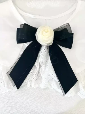 Classic black sheer organza bow hair clip with cream rose embellishment styled with white lace collar, overhead front view of gothic lolita bow accessory