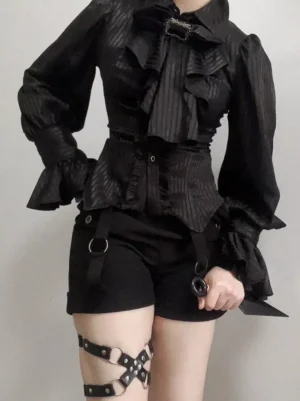Black Ouji lolita high-waist shorts with D-rings metal decorations and ruffled gothic blouse, front view on model with leather harness