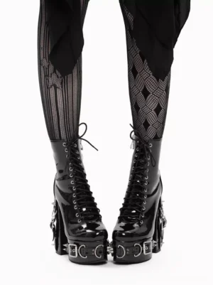 Pair of black patent leather lolita ankle boots with silver hardware, lace-up design, chunky block heel facing each other on model wearing fishnet stockings