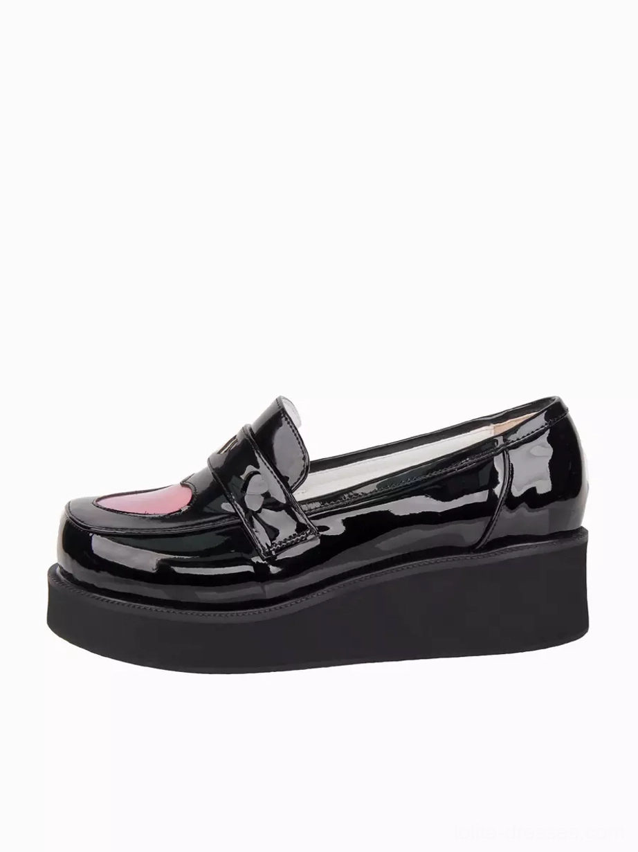 Single black patent leather Lolita platform pump side angle showing thick wedge platform sole and holographic pink heart buckle accent on white background