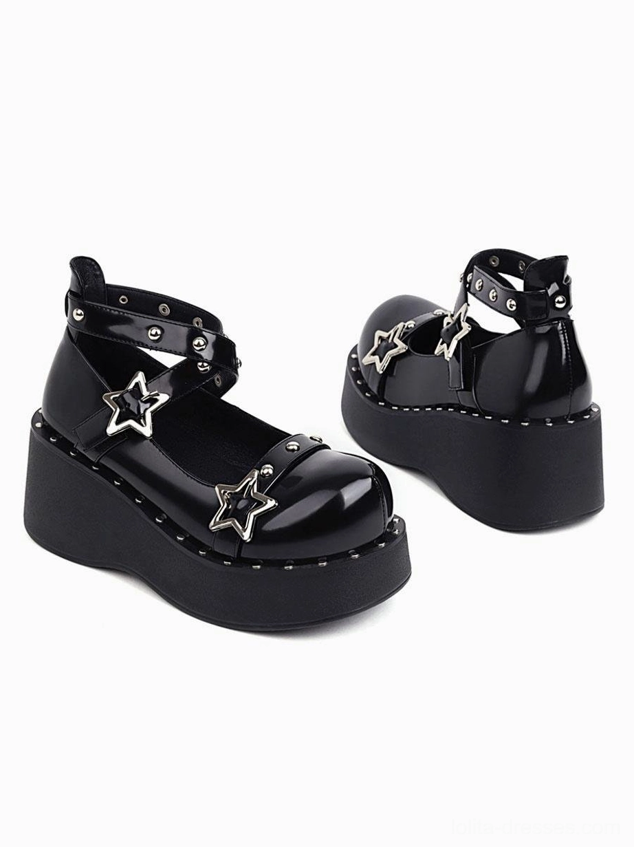 Matching black lolita platform shoes side three-quarter view showing glossy round toe cap and dual star decorations with studded trims