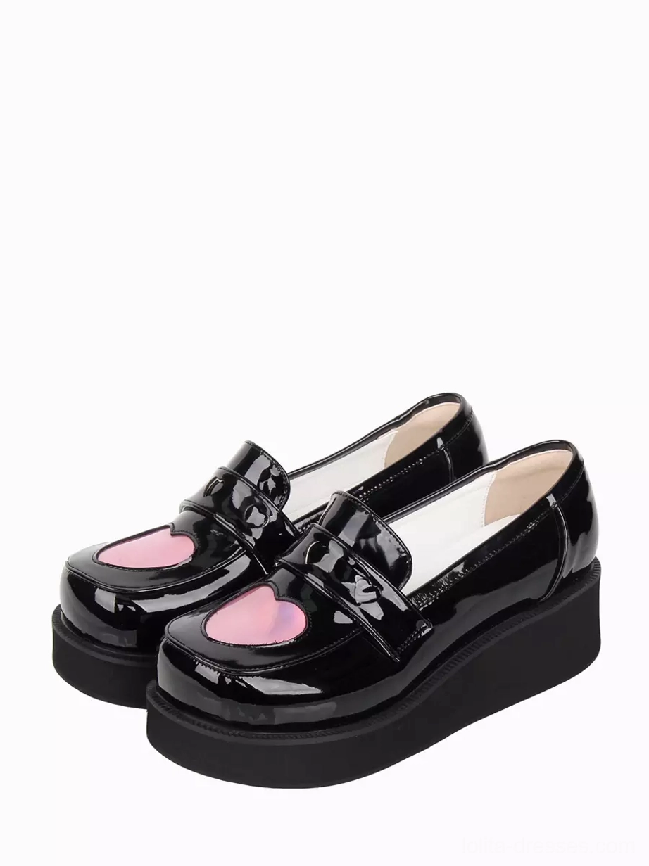 Black patent leather Sweet Lolita platform pumps with holographic pink heart buckle, double shoe oblique front view showing wedge sole and glossy finish