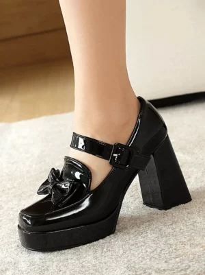 Close-up side angle of black patent lolita mary jane heel showing bow decor and block platform on female leg