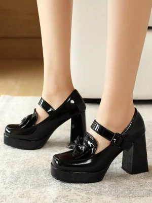 Black patent leather sweet lolita mary jane heels with bow embellishment and ankle buckle strap worn on-feet side view