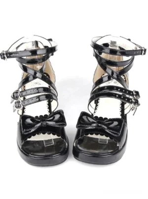 Black patent leather lolita platform sandals front view with dual decorative bows heart-shaped buckle straps studio photography