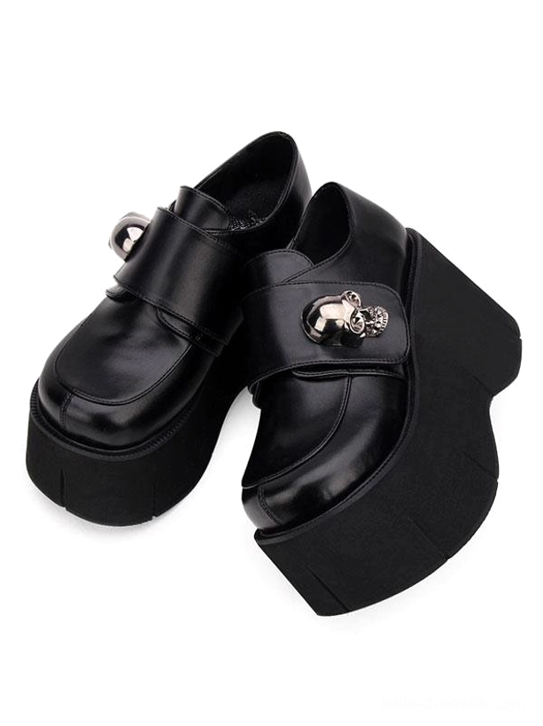 Black platform lolita loafers side three-quarter flat lay angle showing skull metal hardware thick wedge sole glossy finish and round toe design on white background