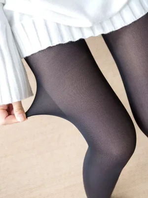 Black semi-sheer lolita pantyhose with plush inner lining shown on model's leg, close-up demonstrating stretchability and matte texture