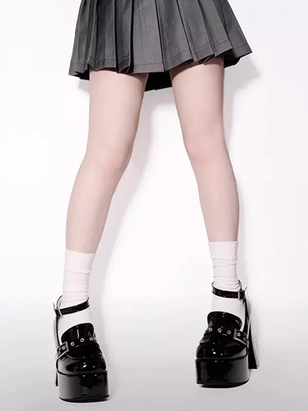 Full leg view of black patent punk lolita platform boots with ankle buckle straps, thick block heels and matching pair shown with gray pleated skirt and white socks