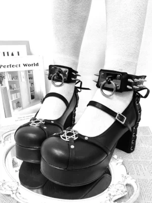 Black punk lolita chunky platform heels with studded ankle cuffs and pentagram front detail worn on feet indoors with mirror tray and books aesthetic