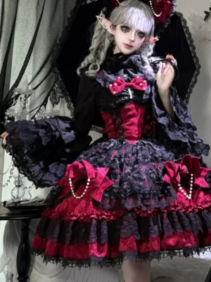 Black and red gothic lolita mini dress with tiered lace skirt and pearl bow details, three-quarter front view on model with ruffled trumpet sleeves in gothic interior setting