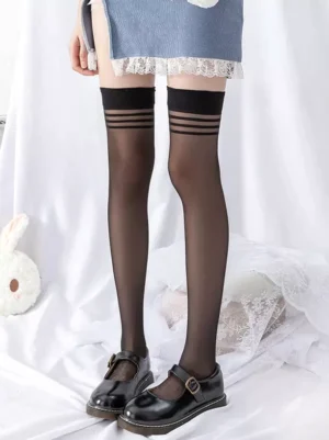 Black sheer over-the-knee Lolita stockings with signature striped cuff detail, styled with blue lace-trim skirt and black Mary Jane shoes, showcasing gothic Lolita fashion styling