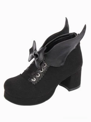 Black suede Gothic Lolita chunky heel pumps with bat wing bow detail, single shoe front-side view showcasing round toe and platform block heel