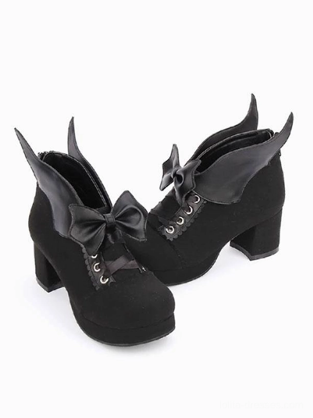 Pair of black suede Gothic Lolita chunky heel pumps with bat wing bow, side view profile showcasing block heel architecture and round toe silhouette