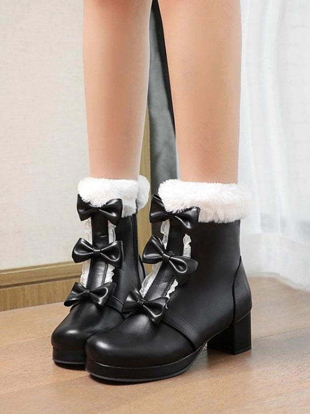 Black Sweet Lolita ankle boots on model feet top-down view featuring double bows, fuzzy fur cuff, block heel, and side zipper closure detail