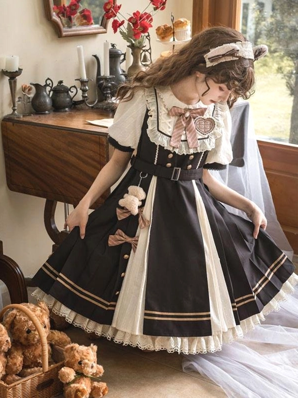 Sweet Lolita dress rear view showing two-tone pleated skirt, teddy bear pendant and lace collar detail against vintage tea room backdrop