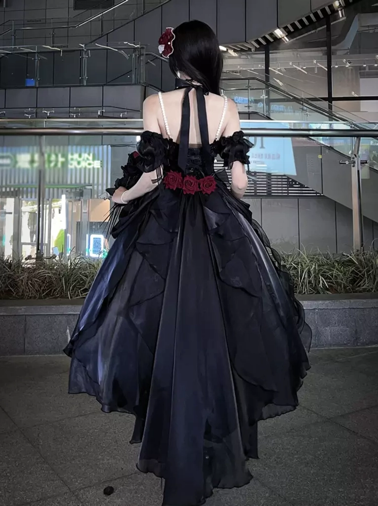 Black sweet lolita dress detail shot showing ruffled construction dimensional embellishments and premium shiny fabric quality