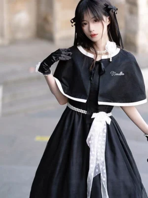 Black sweet lolita dress with pearl capelet set front three-quarter view showing pearl waist belt polka-dot white sash and short puff sleeves