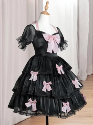 Black sweet lolita dress with pink bows front flat display on dress mannequin with sheer puff sleeves and tiered ruffled skirt