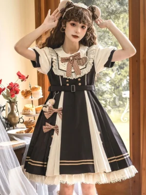 Black sweet Lolita dress front view - short sleeve rococo style with ruffled collar and bow embellishments, worn with bear ear hair accessory in vintage tea room setting