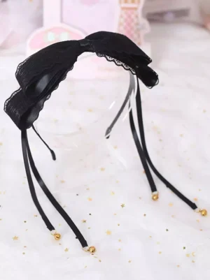 Black sweet lolita hair clasp bow with lace trim and gold bell tassels front view overhead shot