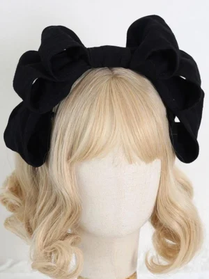 Black matte Lolita bow headdress with layered bow design on mannequin, front presentation highlighting gothic Lolita versatility and structured bow architecture