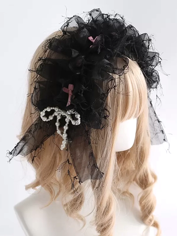 Black sweet lolita ruffled organza headdress with pearl bow accents and pink bow ornaments worn on mannequin with blonde curly wig, three-quarter side view showing delicate frayed tulle edges
