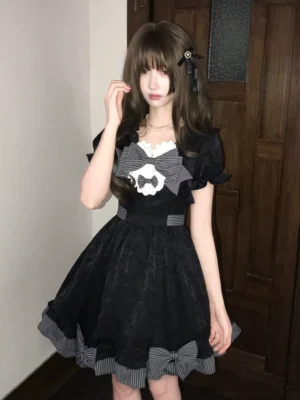 Black sweet lolita mini dress front three-quarter view with puff sleeves gingham bow lace chest detail and striped ruffled hem