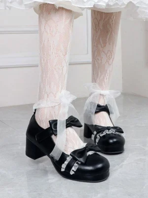 Black sweet lolita block heel pumps with double bow details and round toe, worn with lace stockings and frilly lace-trimmed skirt, low-angle side view