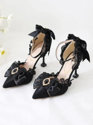 Black sweet lolita stiletto heels with pointed toe ankle strap, delicate lace trim, bow and rhinestone embellishments on white background with floral accents - front three-quarter view