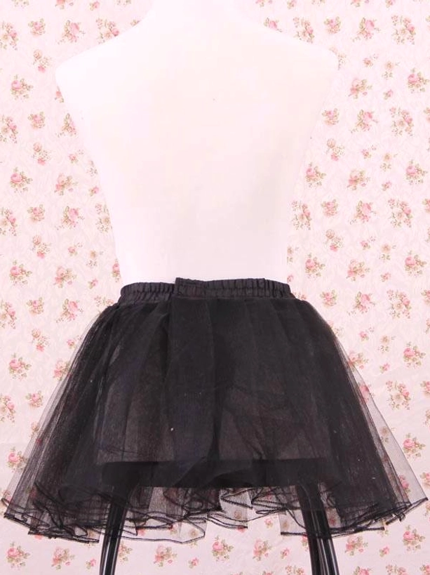 Black tulle petticoat rear-front view on dress form with simple elastic waistband design no satin trim against floral backdrop