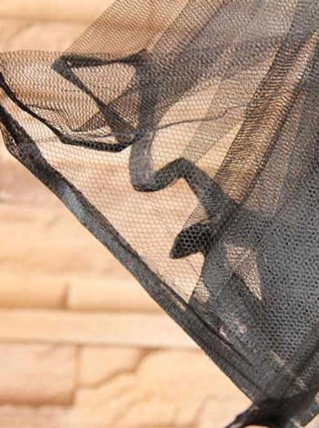 Close-up overhead view of black tulle petticoat detail featuring star-shaped ruffled hem and sheer black mesh fabric texture