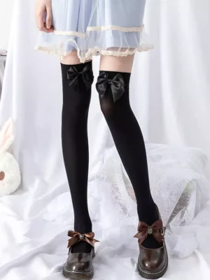 Black over-the-knee lolita socks with black velvet bows worn with blue ruffled dress and brown leather shoes full front standing view