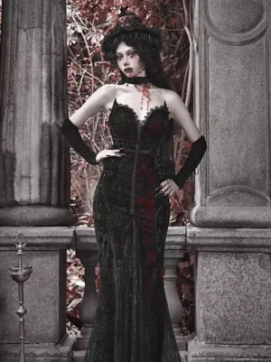 Black velvet Gothic lolita mermaid dress with lace sweetheart neckline and heart print - full body front view on model with gothic makeup and vintage hat against stone balcony background