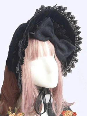 Black velvet classic Lolita bonnet hat with lace ruffled brim and silk bow accent, front close-up view on mannequin