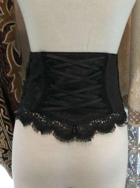 Black classic lolita bustier corset front view with lace-up closure and eyelash lace detail over european patterned background