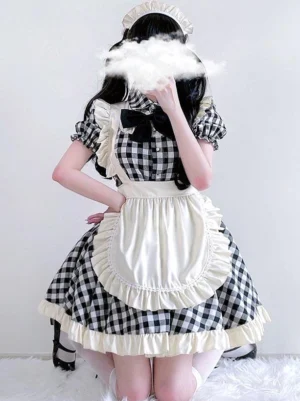 Black and white gingham sweet lolita maid dress rear three-quarter view with ruffled apron and puff sleeves worn by model on fluffy rug