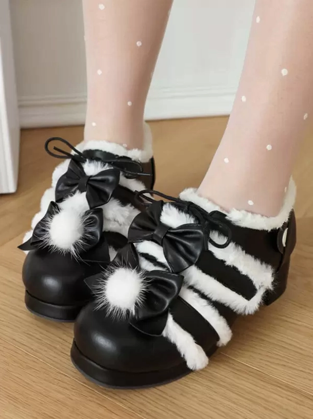 Black-white lolita chunky heels with fuzzy white stripes and pom-pom bow, close-up top view of feet on model wearing polka-dot tights