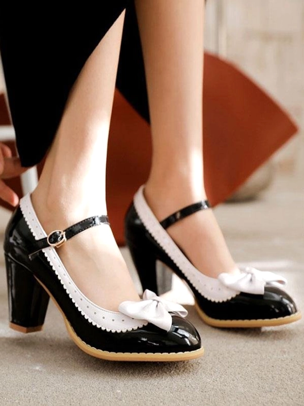 Black and white mary jane lolita pumps side on-foot view indoor floor female model wearing chunky block heel shoes with white bow and black ankle strap